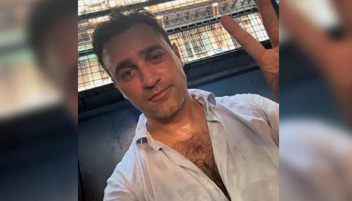 Bollywood actor Imran Khan poses while sitting in a police van after being arrested during an anti-government protest that emerged after the voter list transformation controversy. — Instagram/@imrankhan