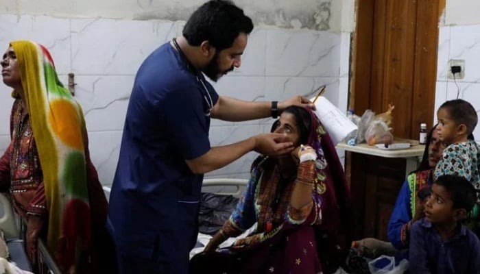 A doctor gives medical assistance to flood-affected girl at Sayed Abdullah Shah Institute of Medical Sciences in Sehwan, Sindh. — Reuters/File