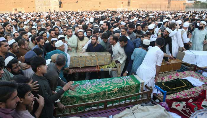 People gather around the coffins of victims who died in a school roof collapse, during a funeral in Peshawar, Pakistan, October 15, 2026.