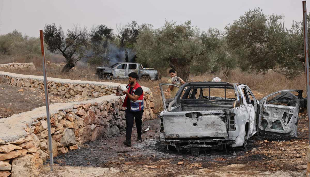 Palestinian volunteers pack hose pipes used to douse an olive tree reportedly set alight, along with Palestinian-owned vehicles, by Israeli settlers near the village of Turmus Ayya, north of the city of Ramallah in the Israeli-occupied West Bank on October 16, 2026.— AFP