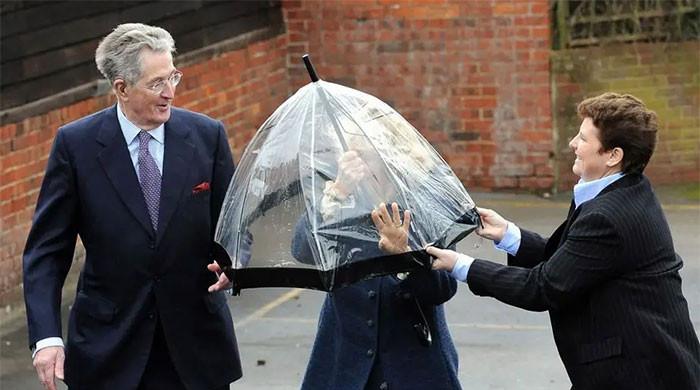 Queen Camilla gets caught in royal pickle after umbrella turns against her