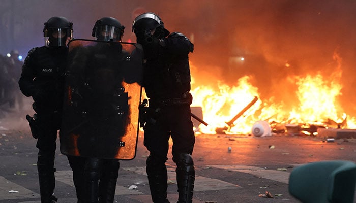 French riot police react next to a burning barricade amid clashes with protesters during a day of demonstrations against the cost of living and rising fuel prices in Paris, France, October 17, 2026. — Reuters