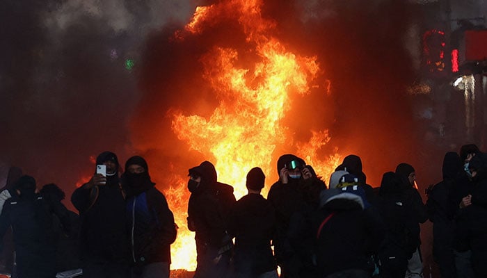 Flames and smoke rise, during civil unrest, the day after a national day of demonstrations against the cost of living and rising fuel prices, in Paris, France, October 18, 2026. — Reuters