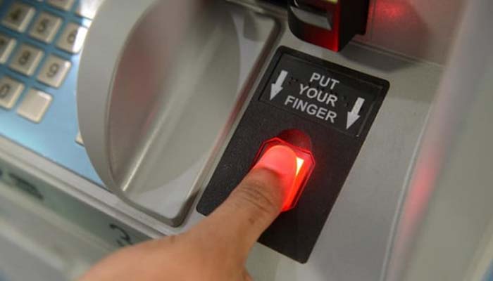 A customer places a finger on a biometric scanner at an ATM. — Reuters