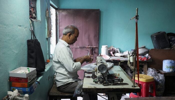 Kamta Prasad, 53, a voter who is listed as Kanta Prasad and is declared dead in the Special Intensive Revision (SIR) list published on August 1, 2026, cleans his glasses at his workstation, in New Delhi, India, October 19, 2026. — Reuters