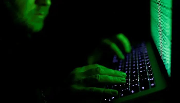 A man types on a computer keyboard in front of the displayed cyber code in this illustration picture taken on March 1, 2017. — Reuters