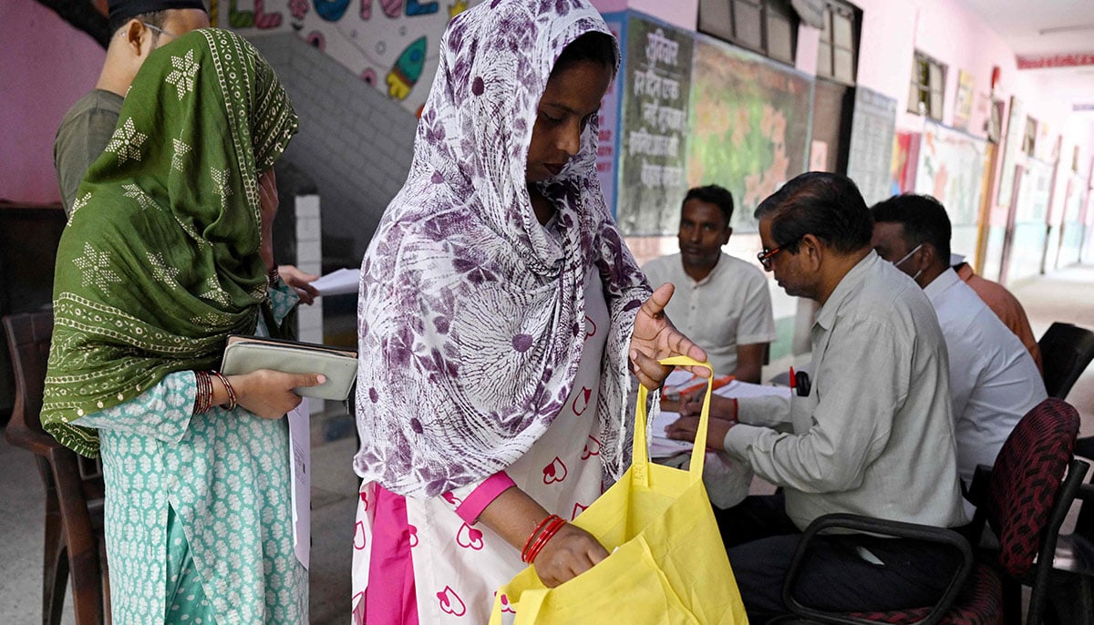 Laddli Khatun (C), a slum dweller searches her bag for documents to register for the Draft Electoral Roll 2026 as part of the Election Commission of Indias Special Intensive Revision (SIR), at a voter verification camp in New Delhi on October 18, 2026. — AFP