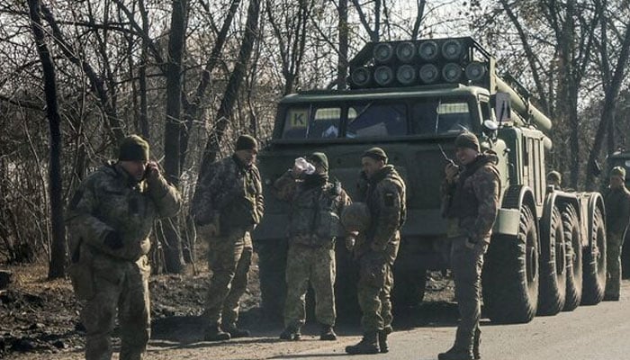 Ukrainian army soldiers stand next to multiple launch missile systems on February 24, 2022. — Reuters