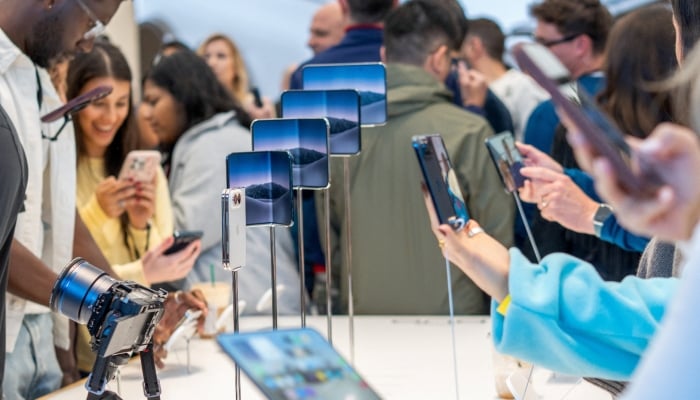 Customers who waited in line to purchase Apples new foldable iPhone Duo phone get hands on the products on the launch day at the Apple store in Austin, Texas, US, October 23, 2026. — Reuters