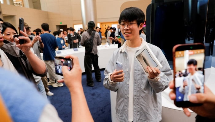 Jialin Jiang, the first customer to purchase Apples new foldable iPhone Duo at the Apple Jingan Store, poses for a photo as the phone goes on sale across China in Shanghai, China, October 23, 2026. — Reuters
