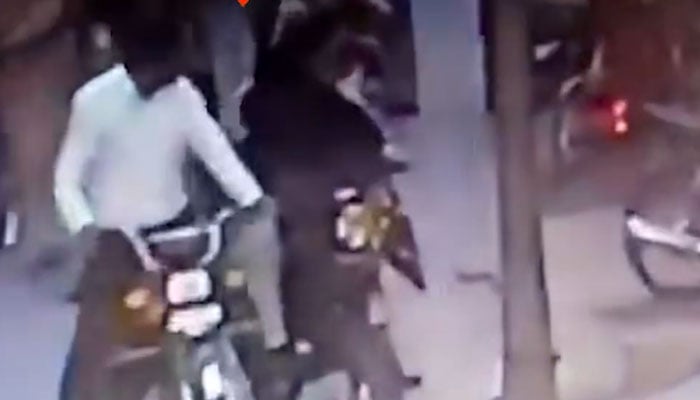CCTV footage captures a man allegedly assaulting a female scooty rider in Lahore. — Screengrab via X/@MurtazaViews