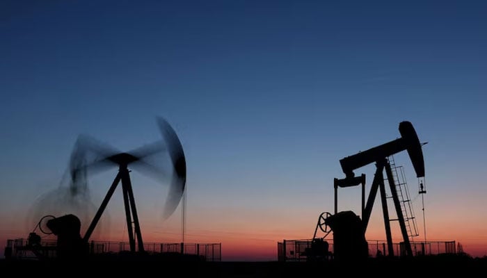 Oil pumps operate after sunset outside Vaudoy-en-Brie, near Paris, France, March 18, 2026. — Reuters