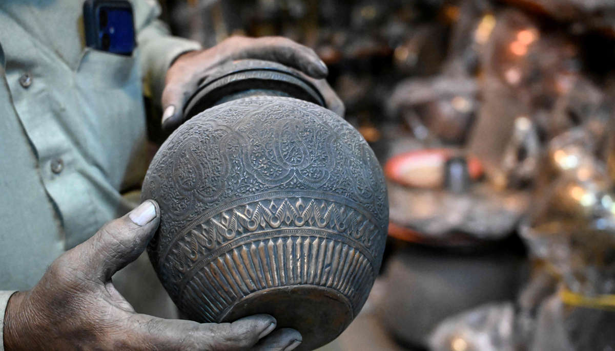 Antique dealer Ahsan Shakeel shows an artefact at his shop selling vintage items in Rawalpindi on October 20, 2026.— AFP