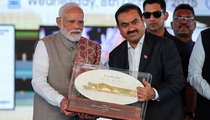 Indian businessman Gautam Adani presents a plaque to Indias Prime Minister Narendra Modi during the inauguration of the Navi Mumbai International Airport in Ulwe, Raigad district, India, October 8, 2025.  — Reuters