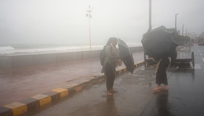 Women shield themselves under umbrellas during high tide amid rain and gusty winds as Cyclone Arnab approaches, in Visakhapatnam, Andhra Pradesh, India, October 27, 2026. — Reuters